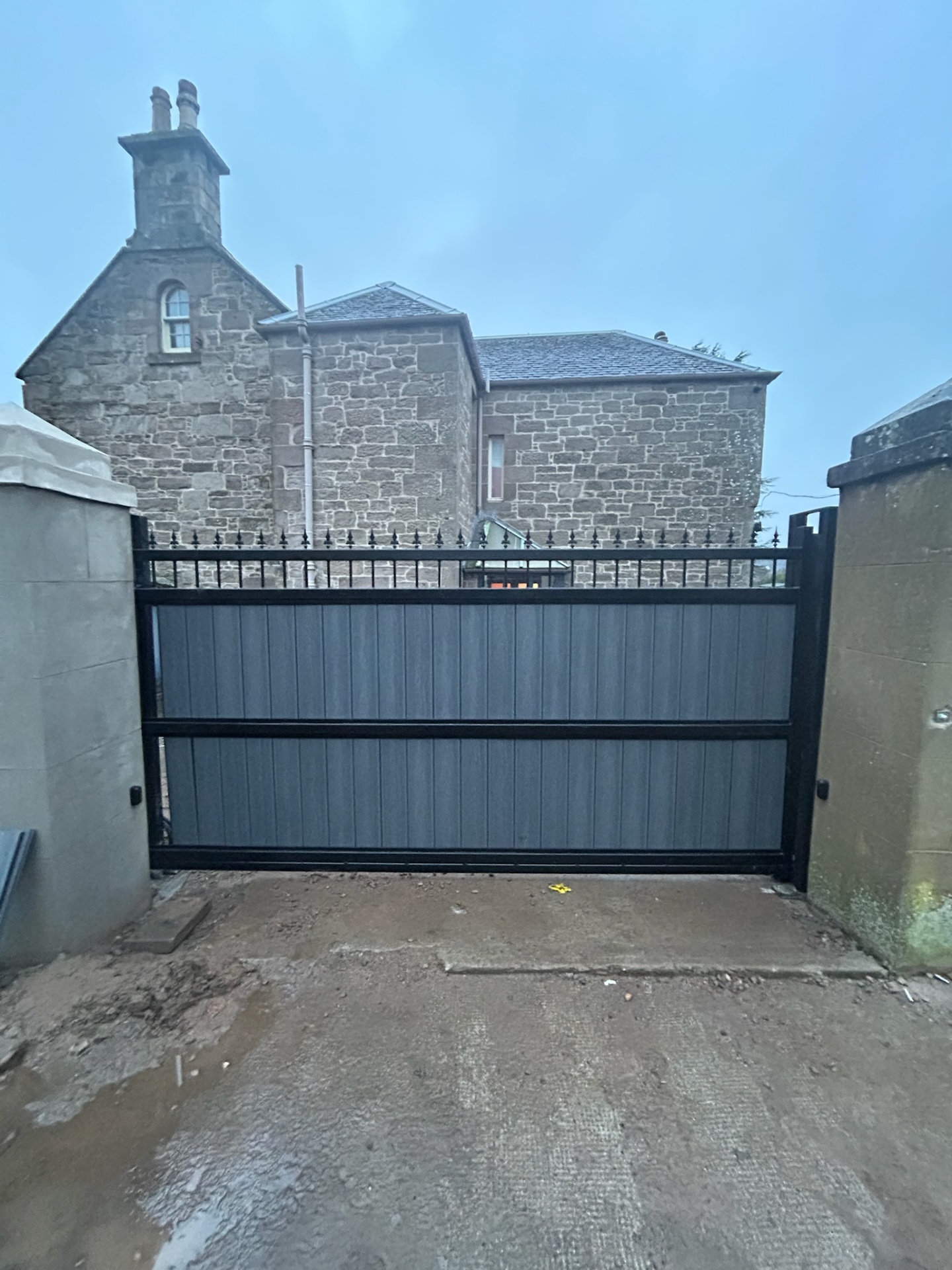 Composite double swing gates with wrought iron finial top detail and keypad entry by KLR Design Limited