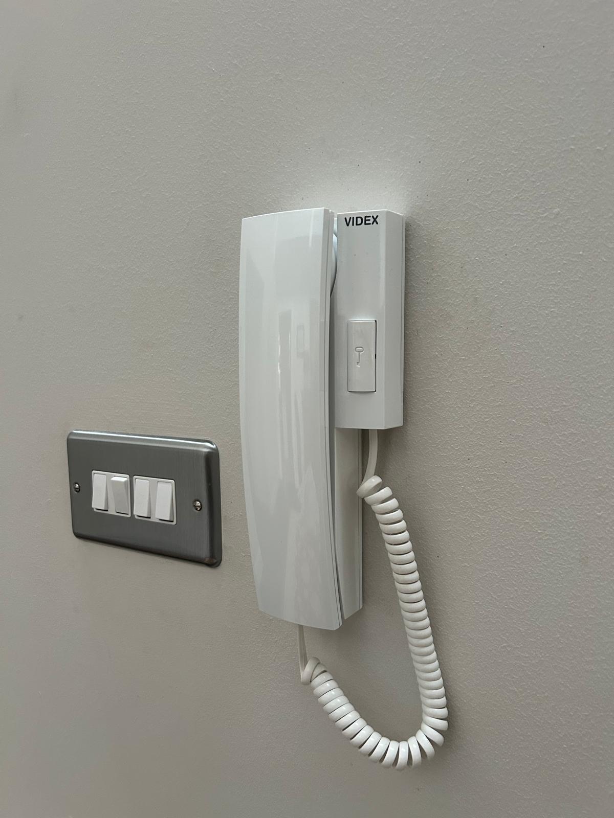 Videx handset intercom installed indoors paired with Tibbermore automated swing gates