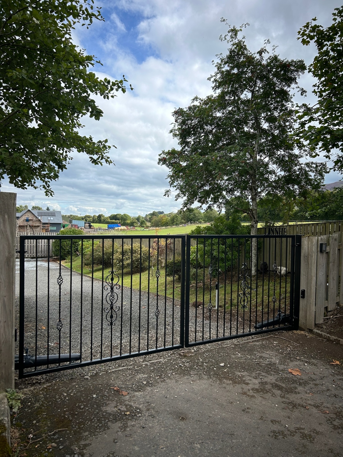 Bespoke black wrought iron double swing driveway gates with decorative scrollwork installed at a rural property in Dumfries and Galloway by KLR Design Limited