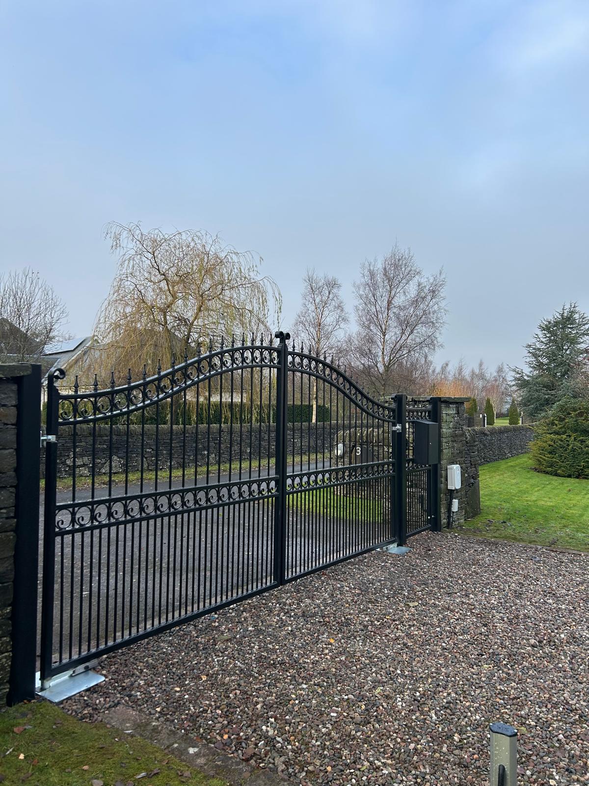 Arched-top wrought iron automated swing gates with scrollwork at Tibbermore Perth by KLR Design