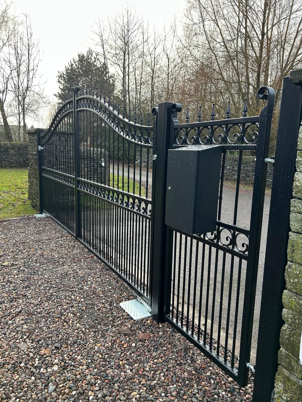 Bespoke swept-top wrought iron style electric swing gates with matching pedestrian gate installed by KLR Design Limited