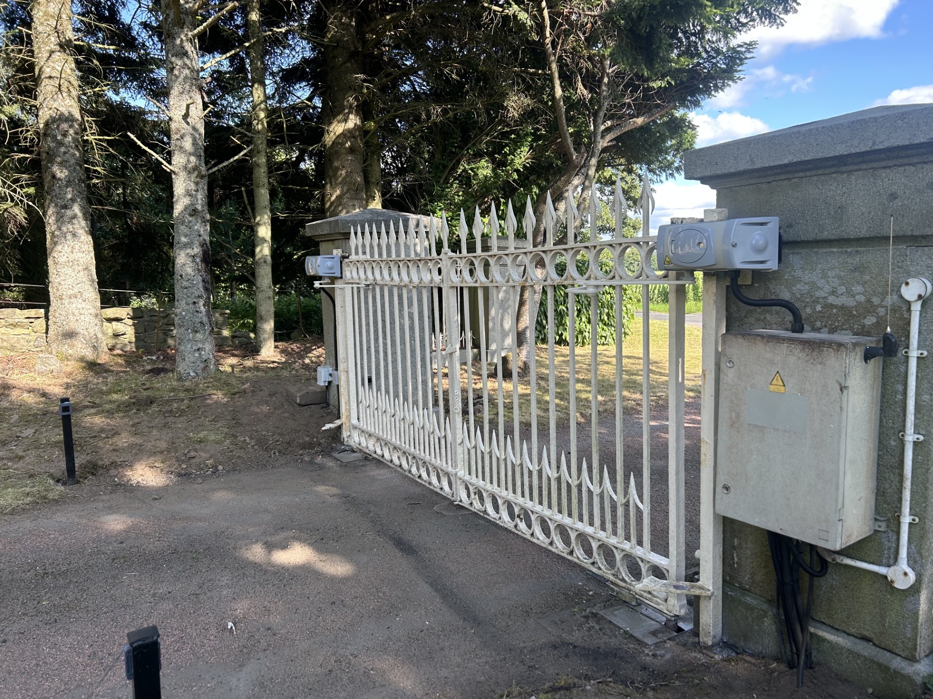 White wrought iron estate gates automated with CAME gate automation by KLR Design Limited